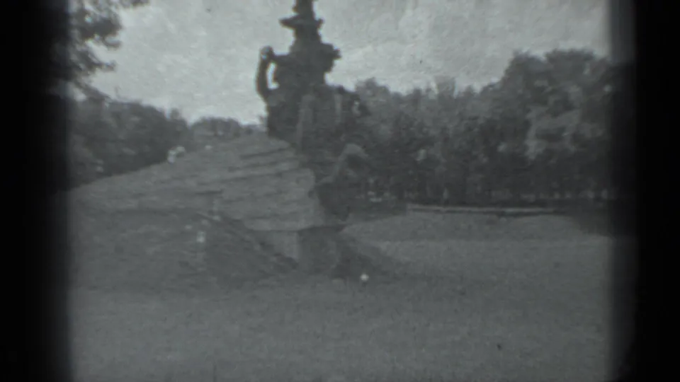 A wide 1983 Moscow frame shows a large outdoor sculptural monument rising above lawn, paths, and surrounding trees.