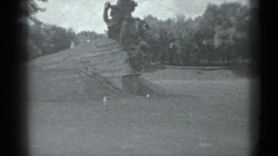 1983 8mm Moscow footage showing broad stone steps, trees, and part of a large public statue near the top of the frame.