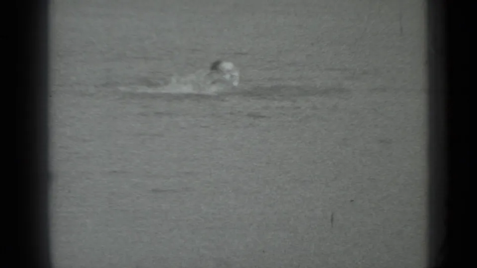 A swimmer appears low in the water in Moscow, Russia, 1983 home-movie footage, framed by dark 8mm projection borders.
