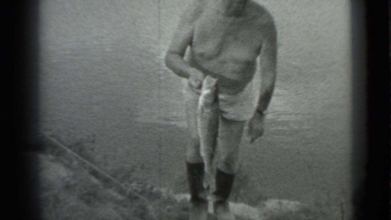 The man steps gingerly up from the riverbank in Moscow, holding a large fish in one hand as the water fills the background.