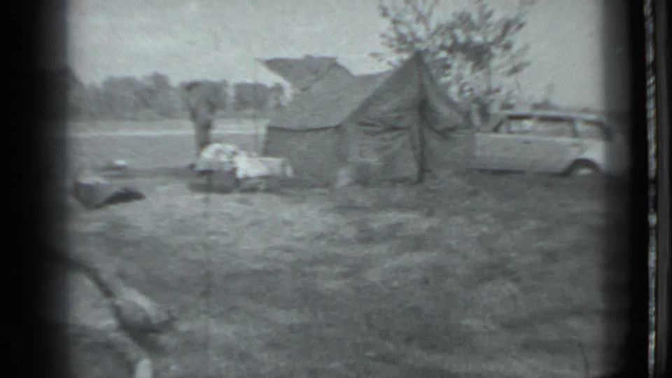 1983 Moscow frame showing a quiet grassy campsite with a person near gear, a canvas tent, and a station wagon.