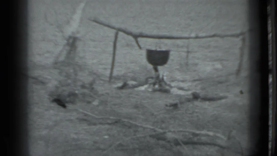 A pot hangs over a simple campfire setup in archival 8mm footage supplied as Moscow, Russia, 1983.