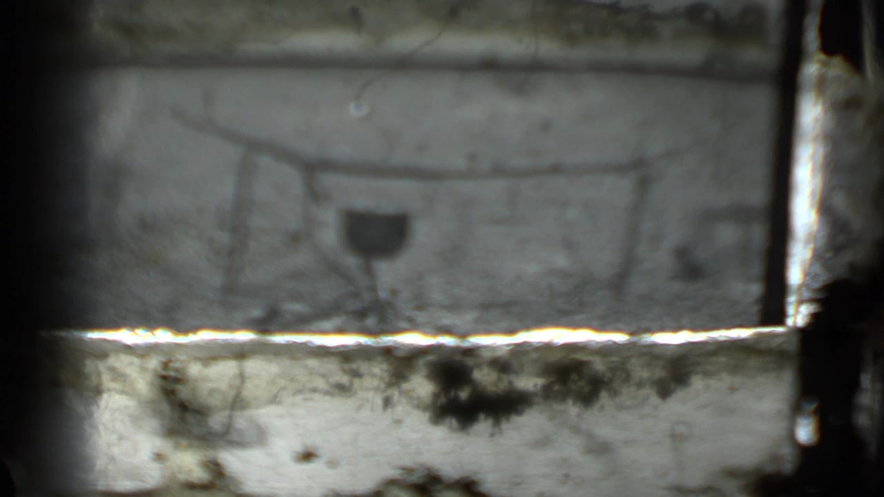 The campfire cooking setup appears again, partly blocked by a bright horizontal film or scan artifact.