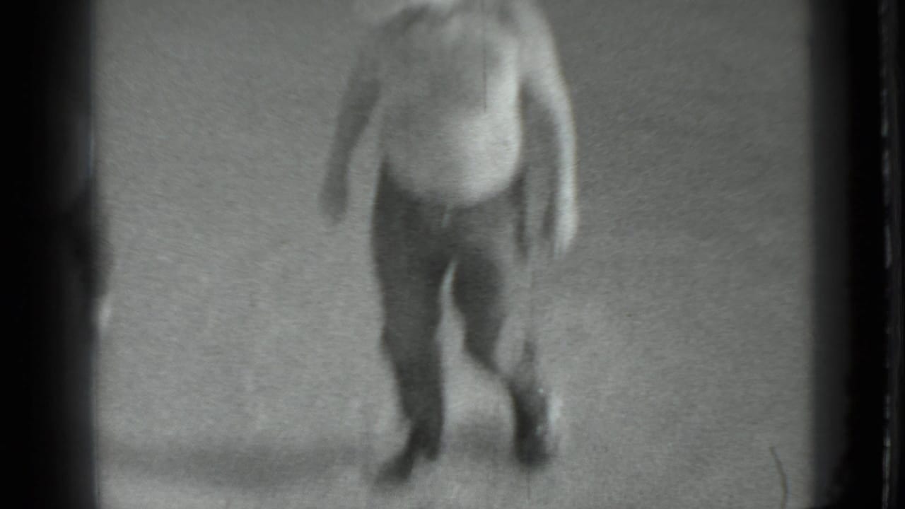 In 1983 Moscow home-movie footage, a blurred adult man moves near a riverbank at the start of the fishing scene.
