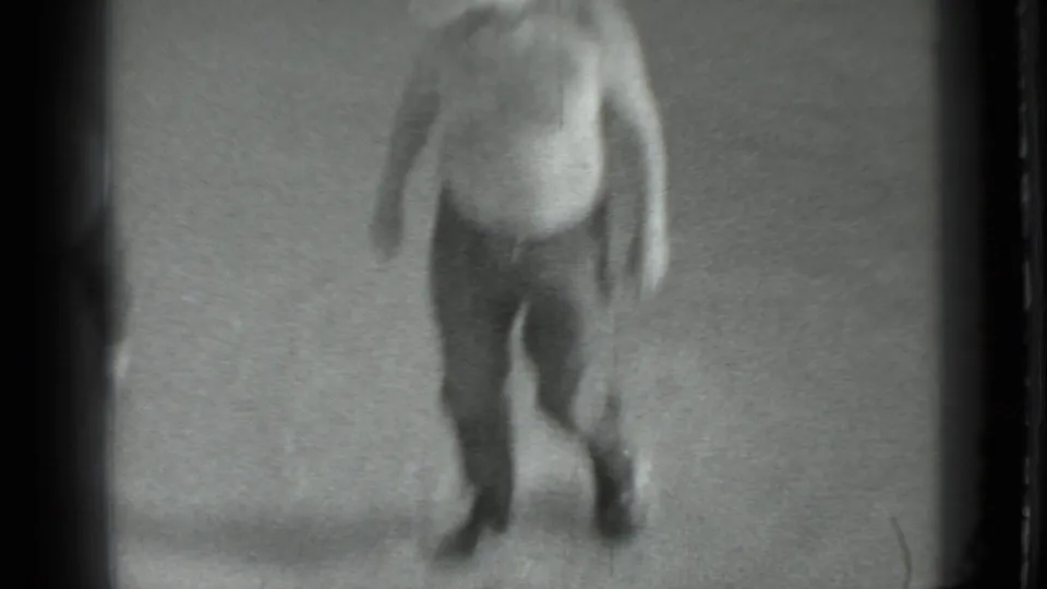 In 1983 Moscow home-movie footage, a blurred adult man moves near a riverbank at the start of the fishing scene.