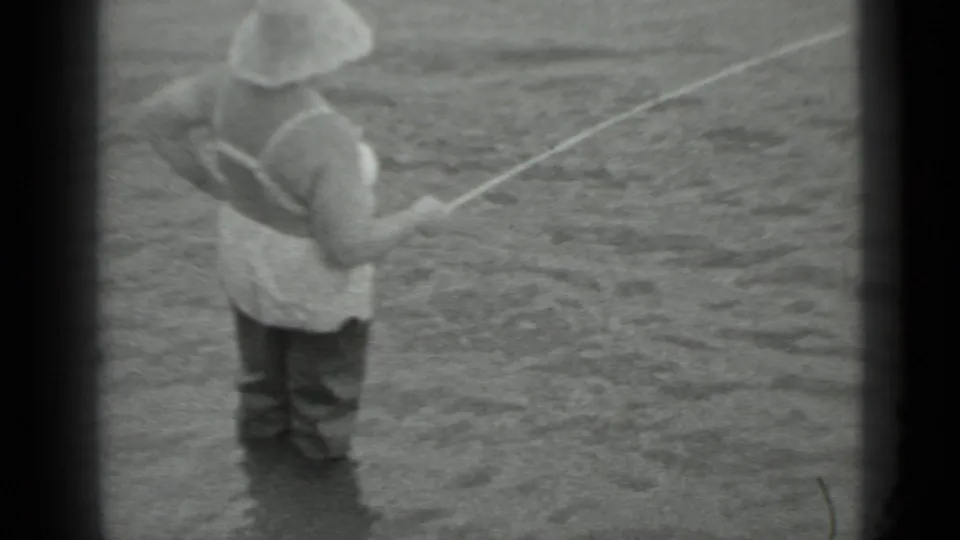 A closer 8mm frame shows the wader-clad fisherman holding his rod across the river surface in Moscow, 1983.