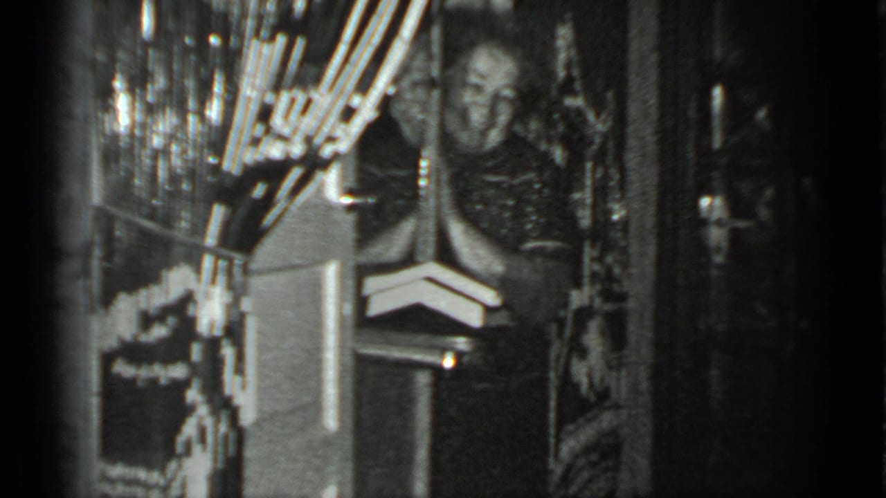 The woman appears to smile toward the camera from a doorway in a Moscow private interior recorded on 8mm film.