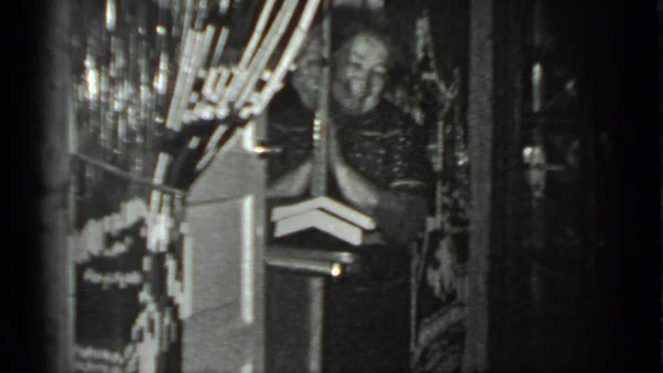 The woman appears to smile toward the camera from a doorway in a Moscow private interior recorded on 8mm film.