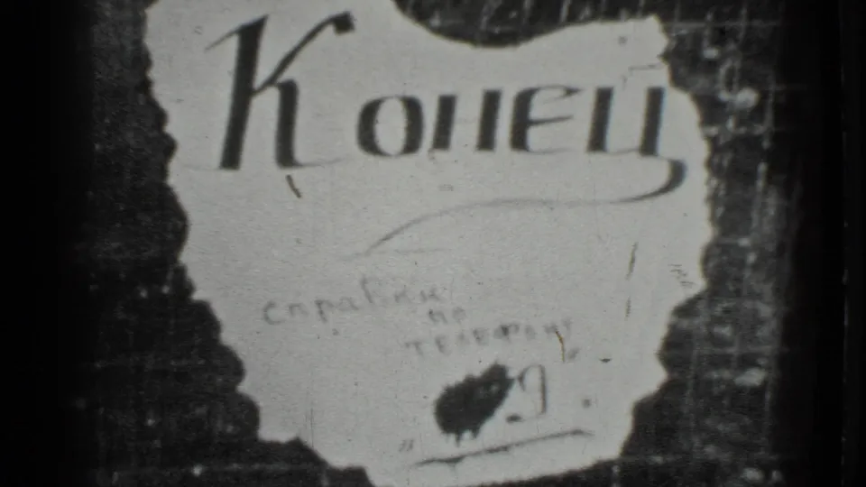 Moscow 1983 8mm close-up of a torn white sign reading "Конец" against a dark, textured backing with visible film wear.