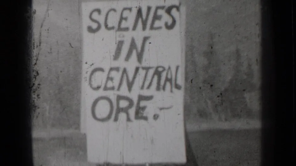 Black-and-white 8mm frame from Bend, Oregon showing the handmade SCENES IN CENTRAL ORE. title board in soft focus.