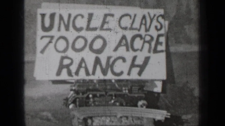 1937 Oregon home-movie still with the Uncle Clays 7000 Acre Ranch sign cropped at left and a vehicle or equipment front below.