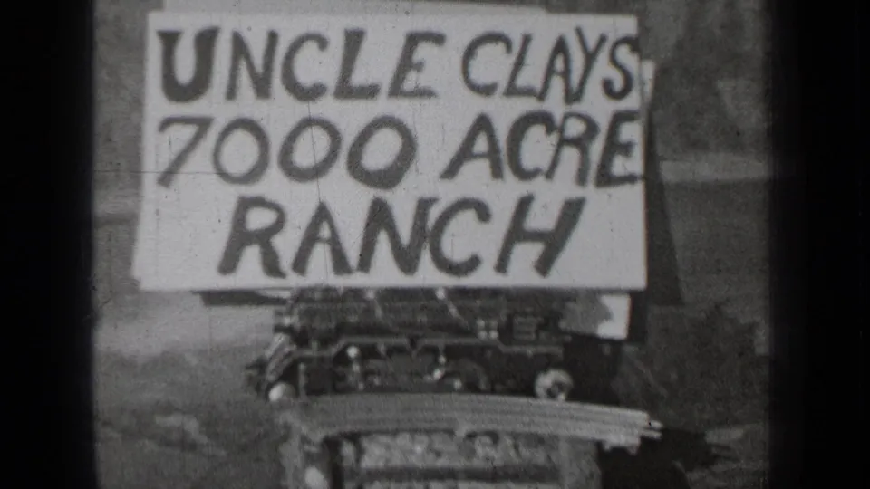Centered black-and-white 8mm view of the hand-painted Uncle Clays 7000 Acre Ranch sign in the stated Bend, Oregon clip.