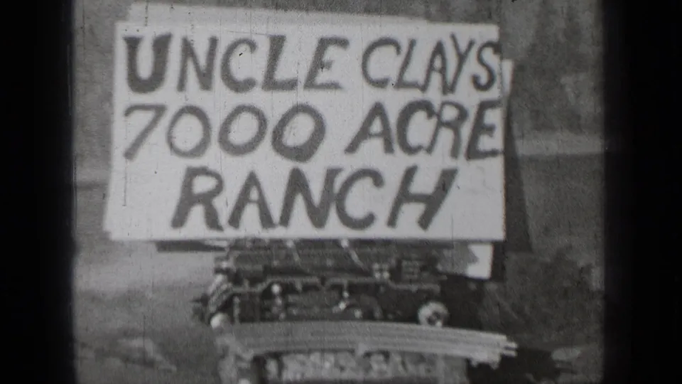 Black-and-white 8mm view of the Uncle Clays 7000 Acre Ranch sign near Bend, Oregon, with a vehicle partly seen below.