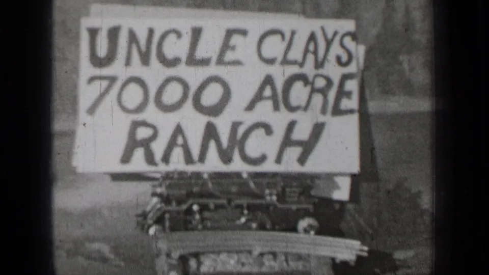 Archival 8mm frame showing the Uncle Clays 7000 Acre Ranch sign in a rural outdoor Bend, Oregon setting.
