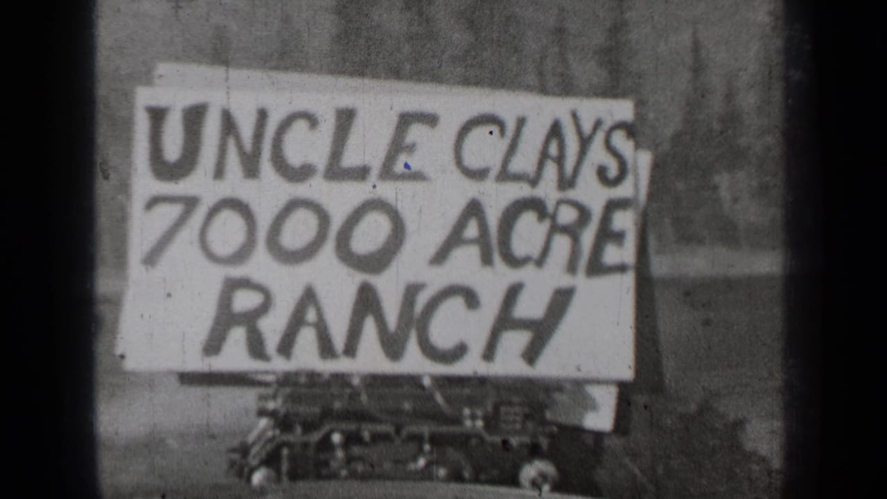 Hand-painted sign reading Uncle Clay’s 7000 Acre Ranch beside a parked car.