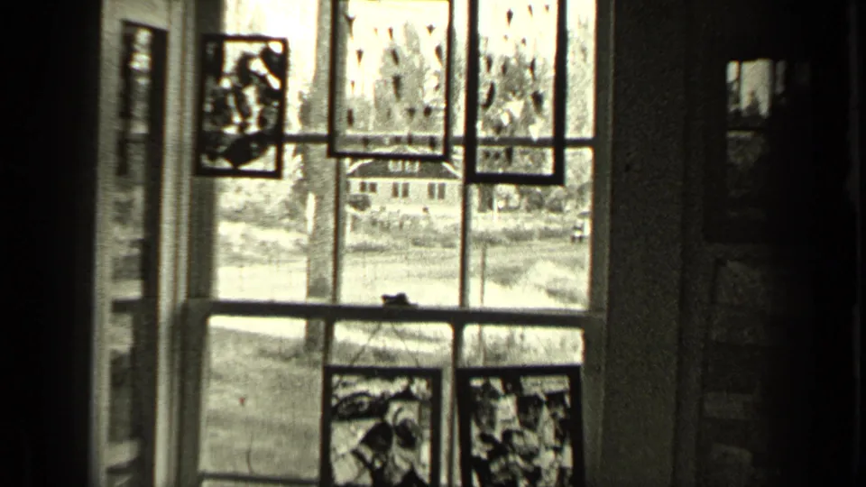 Wider 1937 Bend, Oregon interior frame showing a decorated window looking out toward a quiet residential street.