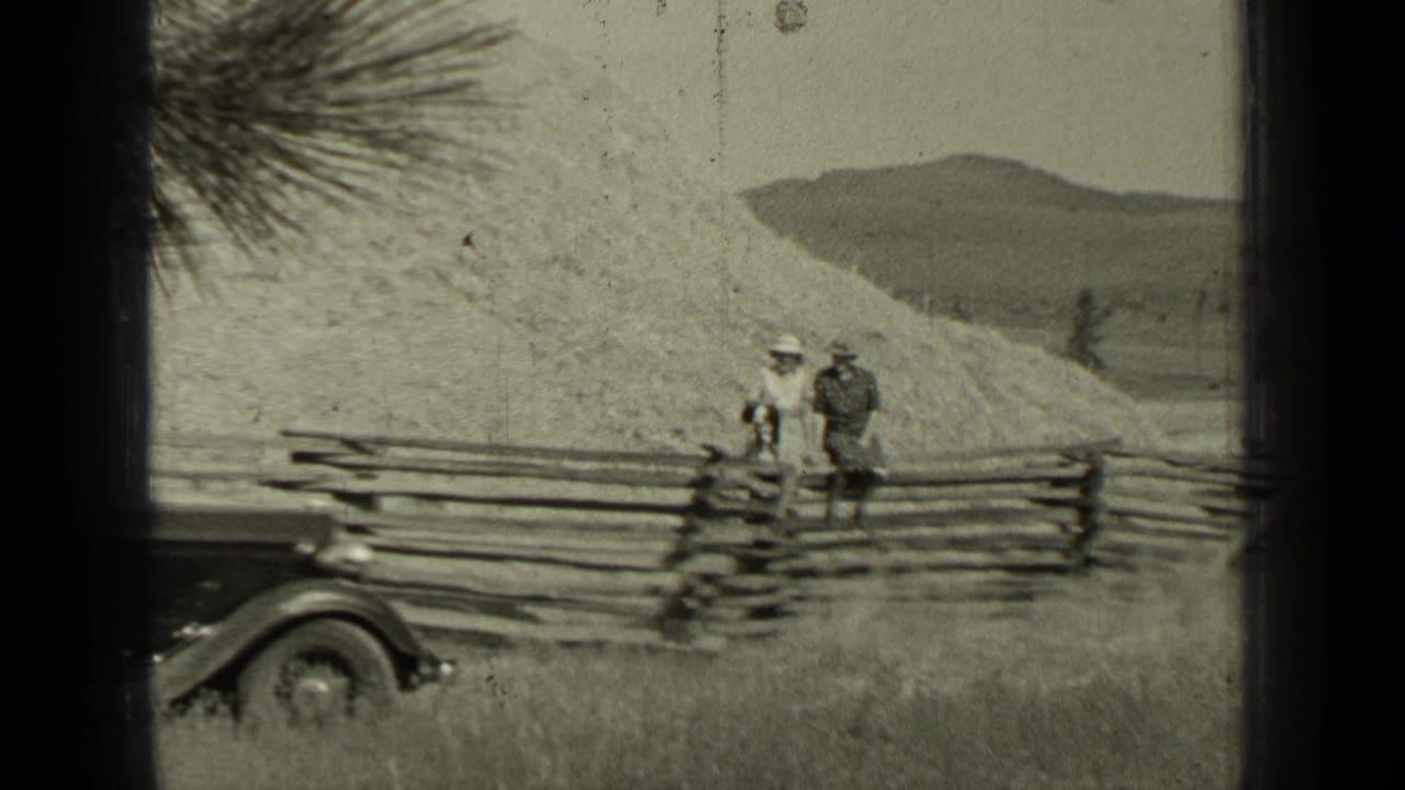 The Bend, Oregon scene shows two adults by a fence, with part of an early automobile visible against hills and open grass.