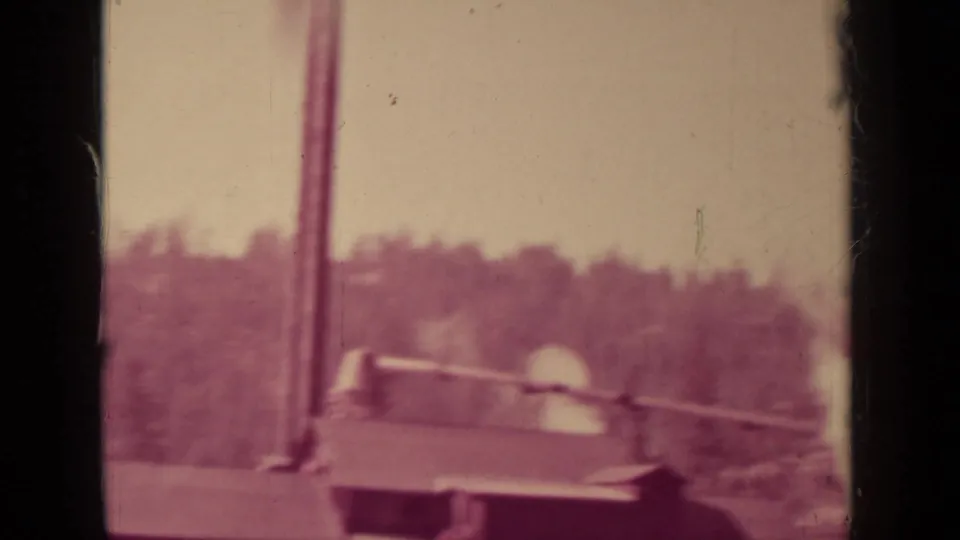 1937 Klamath, California 8mm frame with a mill roof, vertical stack, and pale smoke or steam in a wooded setting.