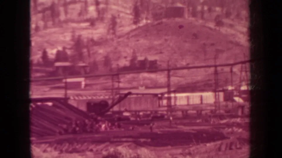 1937 Klamath, California mill yard with a sloped conveyor, timber-processing area, long building, and forested slope.