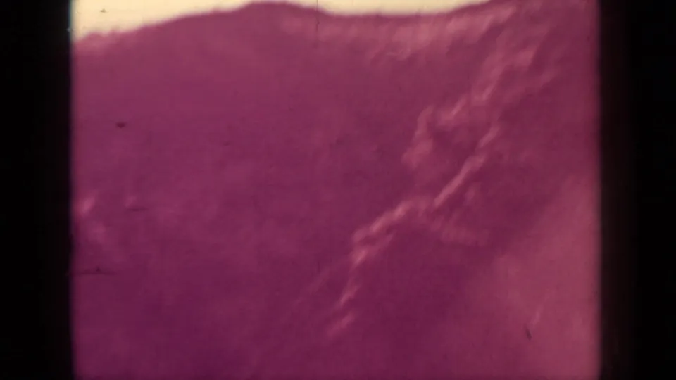 Final 8mm frame showing a blurred hillside and brush near Klamath, California, with aged color shift.