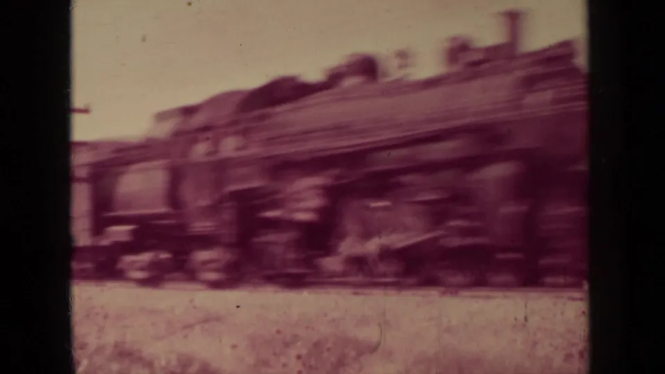 Steam locomotive passes through the Klamath, California frame, softened by motion blur and reddish 8mm color shift.
