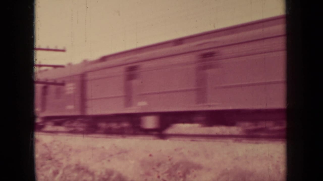 A passenger train moves past trackside utility poles in 1937 home-movie footage from the Klamath, California clip.