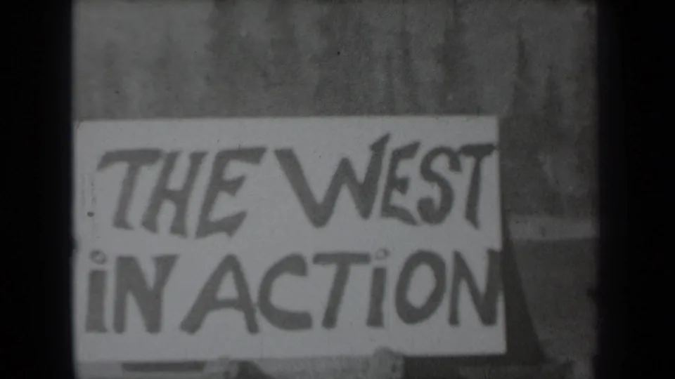 Part of a hand-drawn sign reading THE WEST IN ACTION appears on the 1937 Klamath 8mm film, partially blocked by a dark frame divider.
