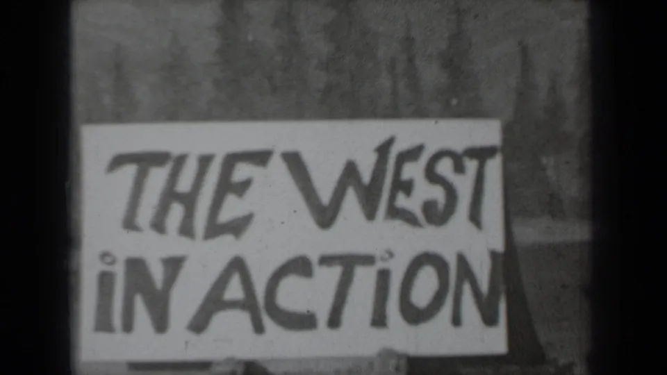 1937 Klamath, California 8mm frame showing a hand-painted THE WEST IN ACTION sign against a pine-tree backdrop.