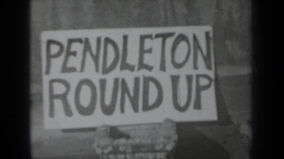 1937 Klamath, California home-movie frame showing a Pendleton Round Up placard held against a simple outdoor backdrop.