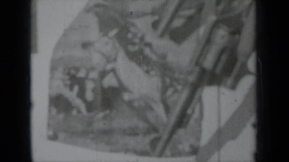Soft black-and-white 1937 Klamath home-movie frame with a long gun held near a rodeo-themed poster.