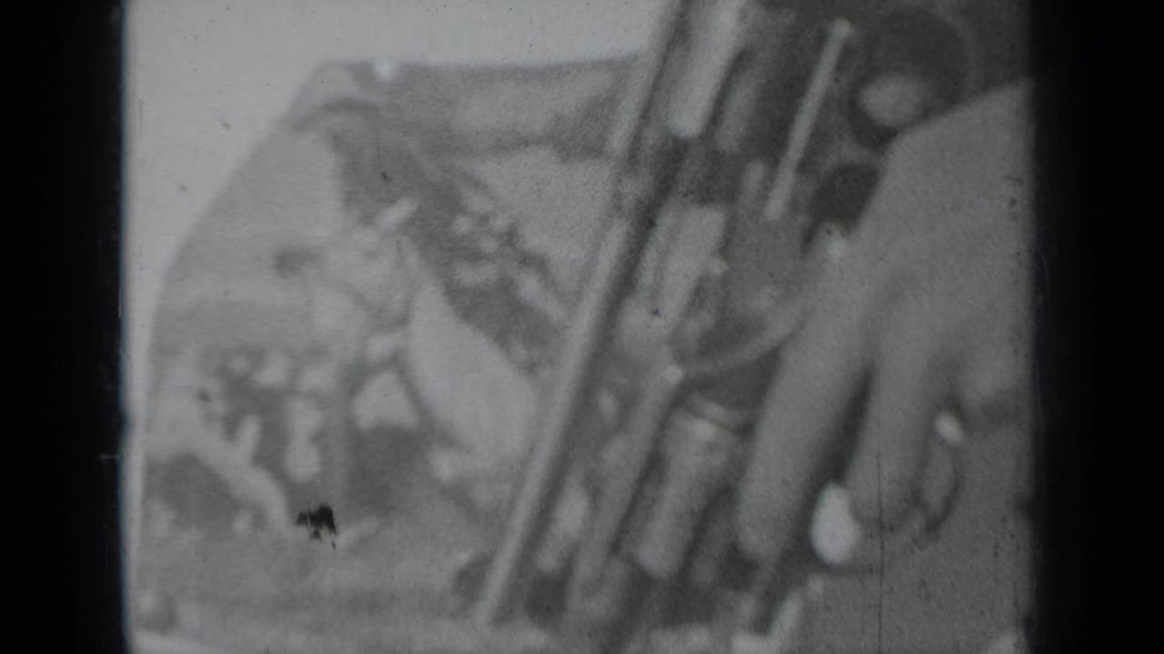 Close-up of a hand holding a revolver against a blurred outdoor background.