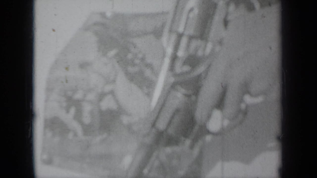 Soft 8mm frame showing a hand with a revolver, likely at the documented 1937 Klamath, California event setting.