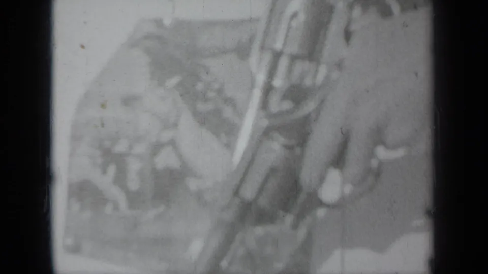 Soft 8mm frame showing a hand with a revolver, likely at the documented 1937 Klamath, California event setting.