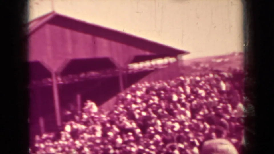 A dense baseball crowd gathers near the end of the wooden Klamath grandstand, with faces too small for reliable identification.