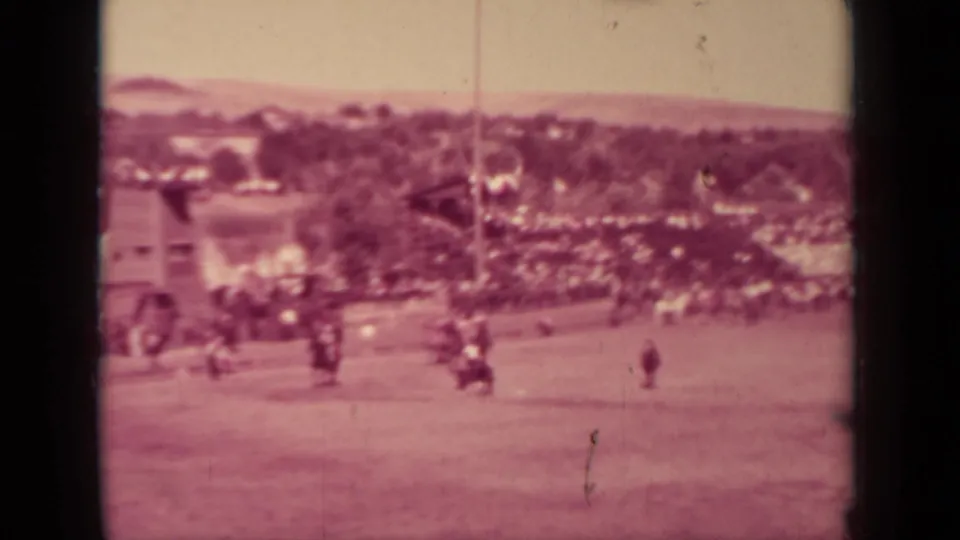 Wide 1937 Klamath, California home-movie view of the racing grounds with spectators, open track, trees, and distant structures.