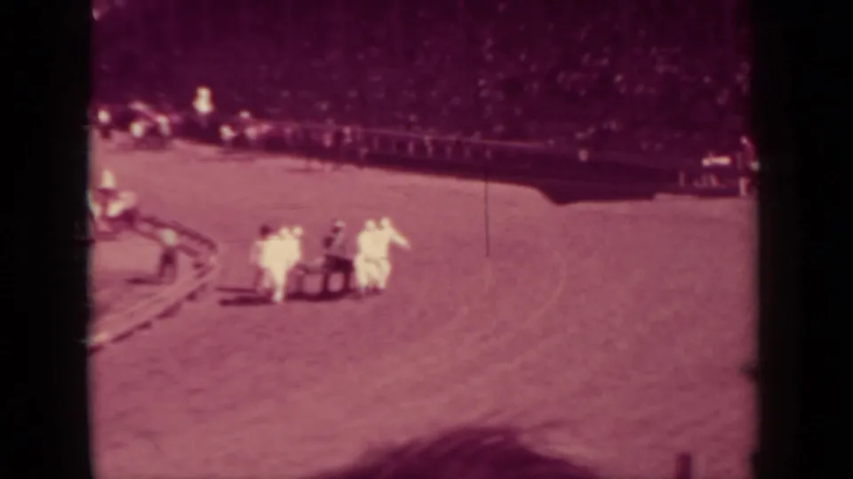1937 Klamath, California racing scene showing attendants with a stretcher on the dirt track while the grandstand watches.