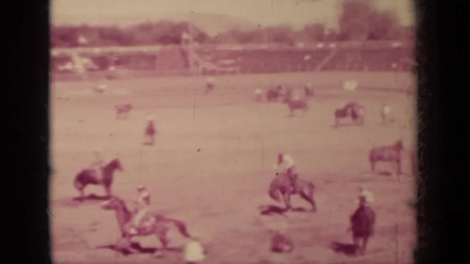 1937 Klamath, California rodeo scene with several cowboys on bucking horses and a crowd beyond the arena.