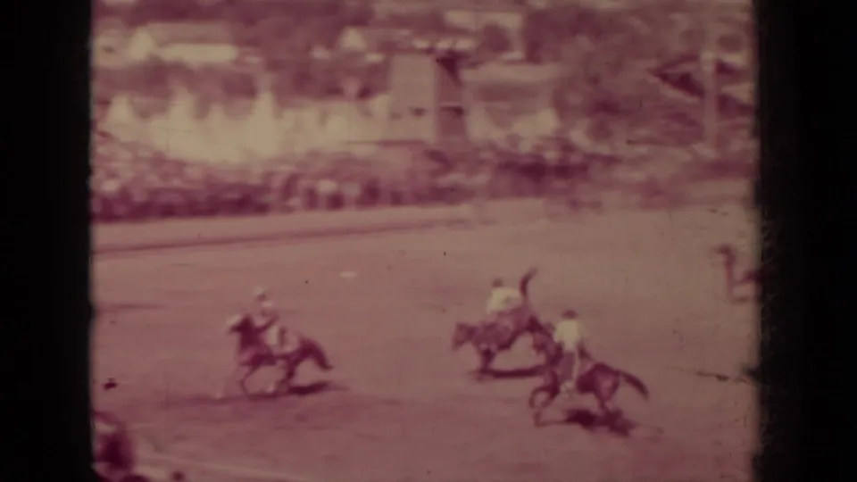 1937 Klamath, California rodeo footage showing mounted riders moving across a dusty arena while spectators sit beyond the field.