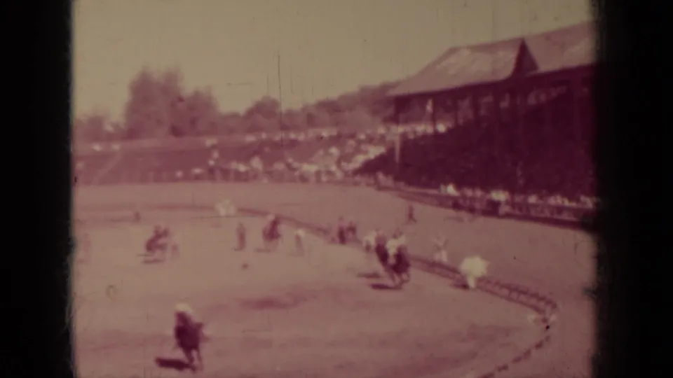 Wide 1937 Klamath, California view of riders spread along a dirt race track with a covered spectator stand at right.