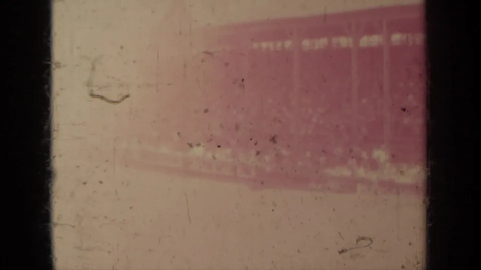 Faded 1937 8mm frame from Klamath footage, showing mostly film leader or overexposed area with scratches and a reddish patch.