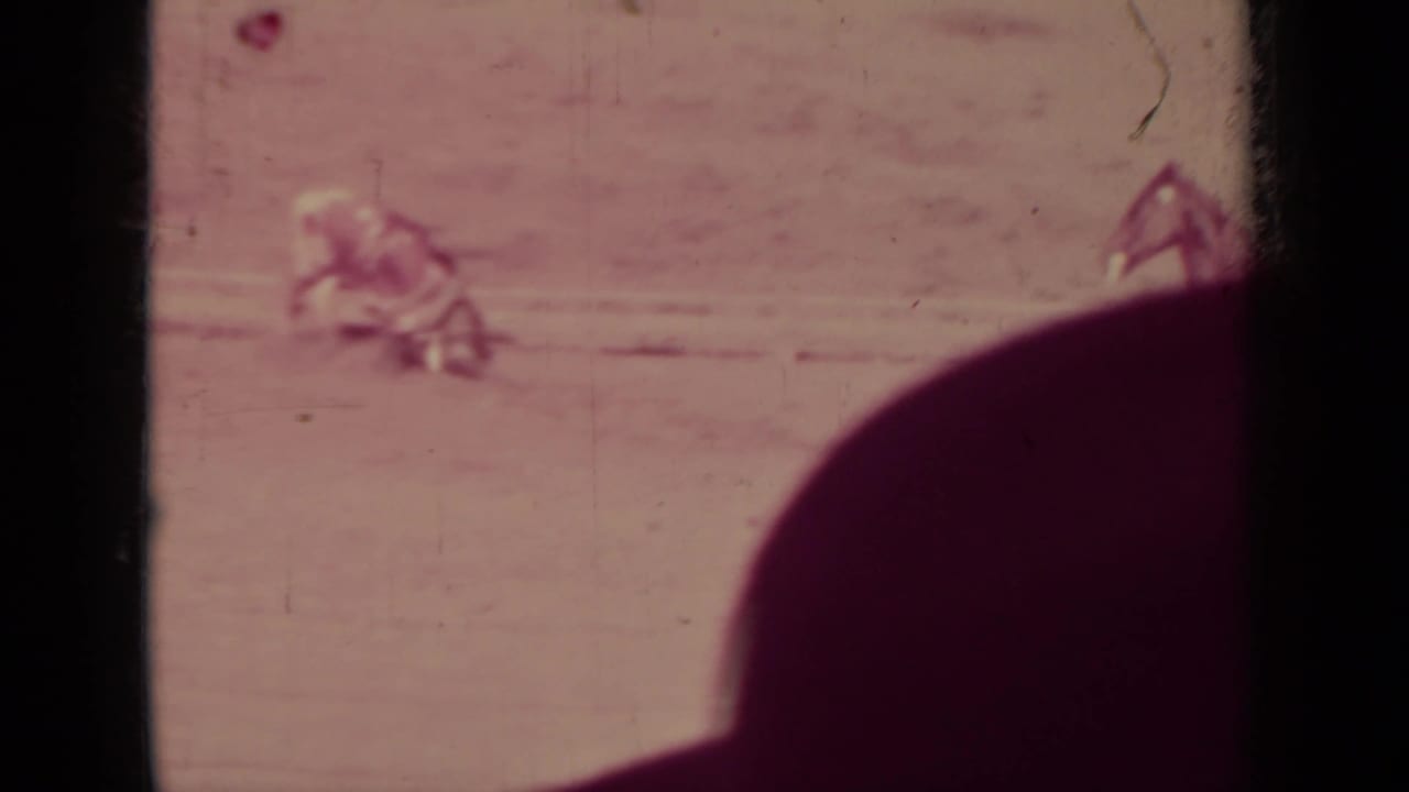 Distant rider and livestock on open ground with a dark foreground obstruction.