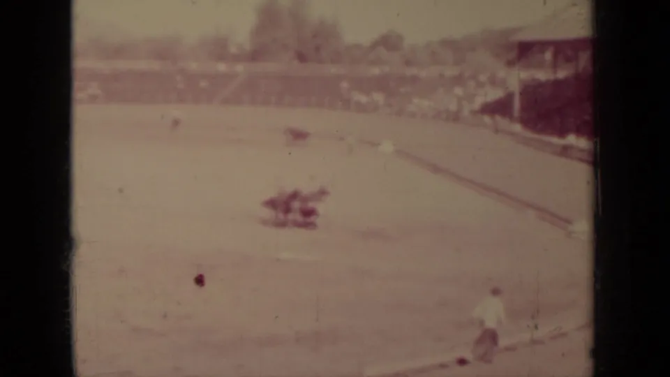 Wide 8mm view of a Klamath outdoor arena, with a horse and rider on the dirt track and distant bleachers behind.