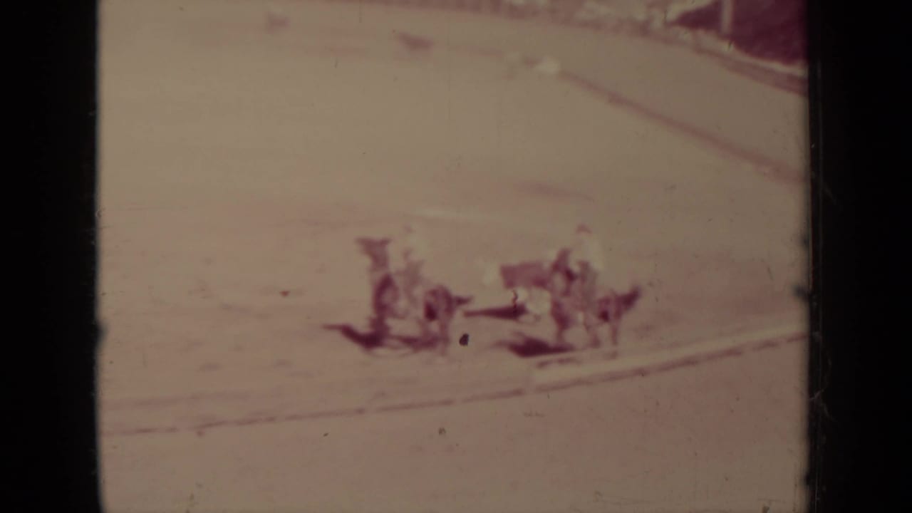 Klamath, California 8mm frame showing several horses and riders grouped on a bright dirt arena track.