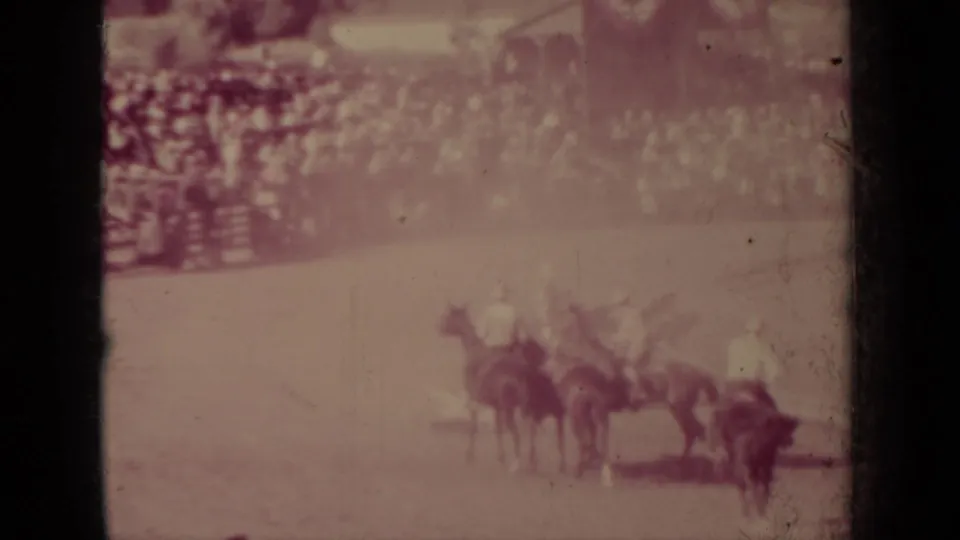 A group of mounted riders and horses cluster in the arena during the 1937 Klamath rodeo, filmed from a spectator viewpoint.