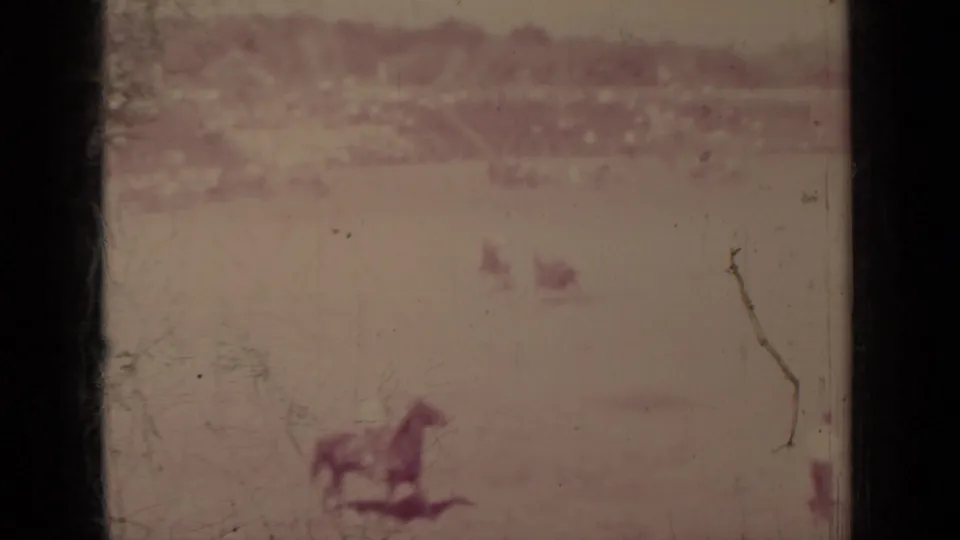 1937 Klamath, California 8mm frame showing a distant rider on horseback on an open field before a soft crowd line.