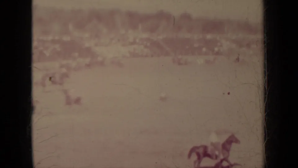 A distant horse and rider move near the right side of the Klamath field, with spectators faintly visible along the horizon.