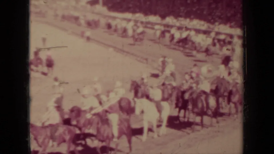 1937 Klamath, California home-movie frame showing riders on horseback near a spectator line in a dusty outdoor setting.
