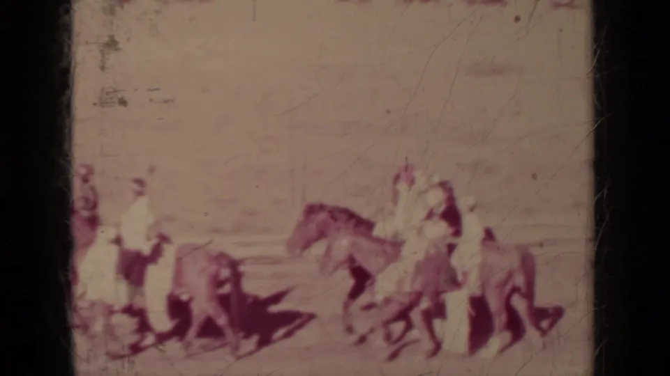 In Klamath, California, 1937, riders on horseback and people leading horses appear in a sunlit outdoor parade scene.