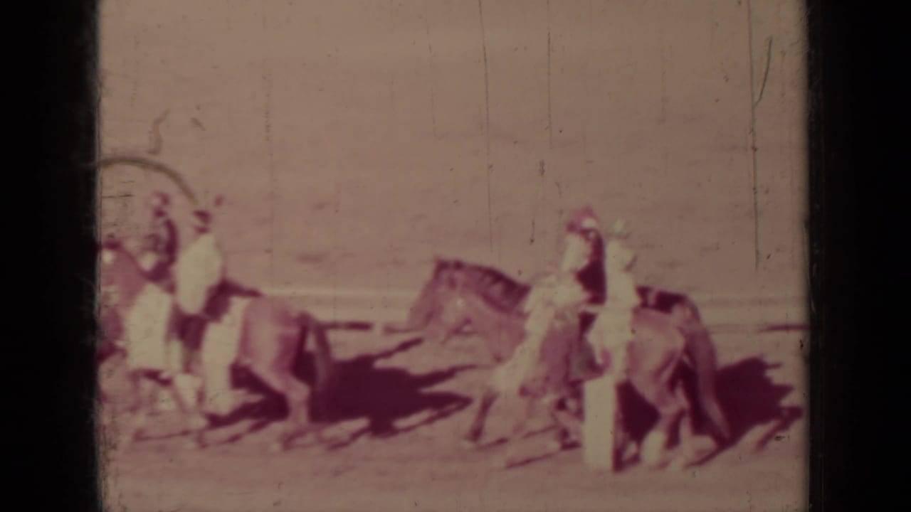 A 1937 Klamath parade view shows several horseback riders and a nearby walker moving across an open dirt area.