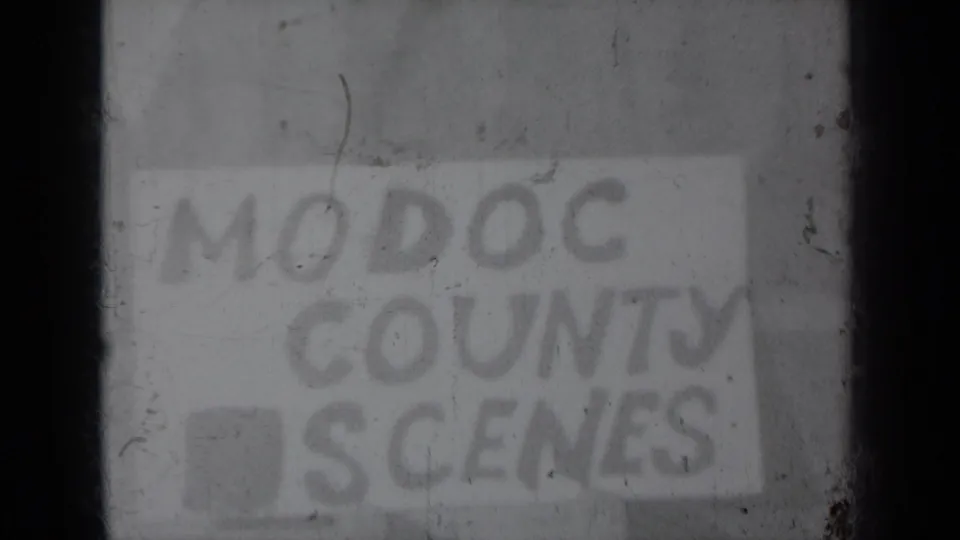 Soft, worn 8mm frame showing the “MODOC COUNTY SCENES” title card, with scratches and low contrast across the image.